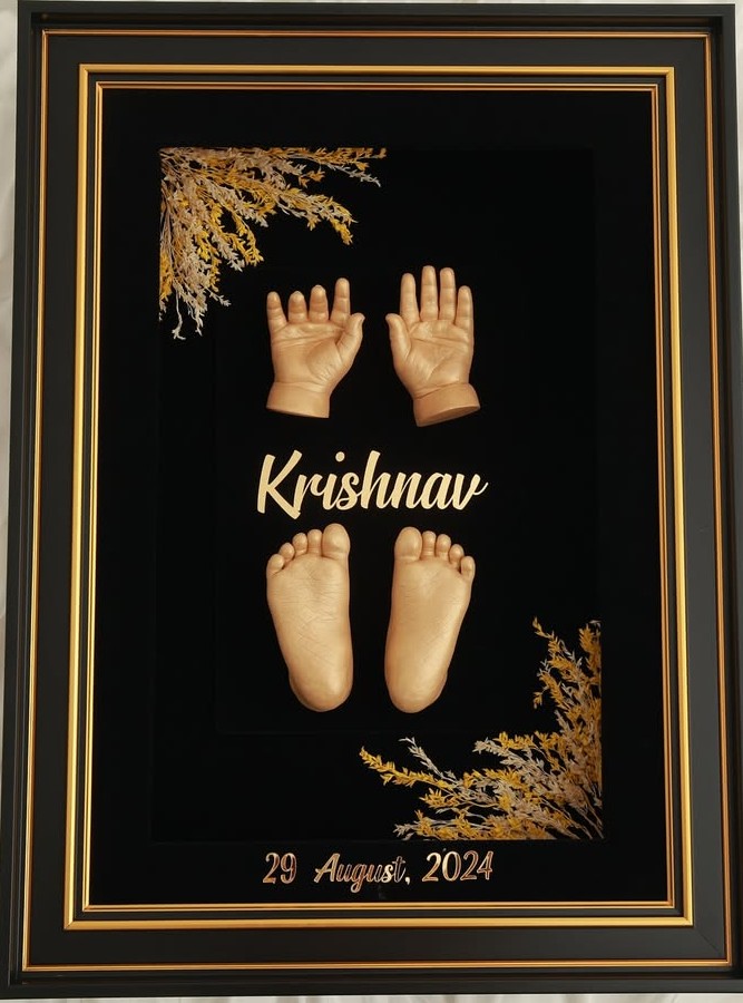 Delicate white plaster cast of baby's tiny hand in mother's palm, showing intricate fingerprint details and soft curves